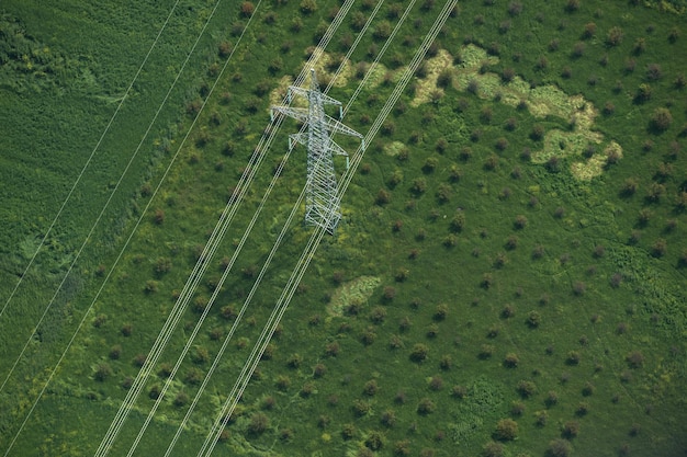 An aerial view of a large-scale solar farm stretching across an arid landscape under a clear sky, with power lines connecting the panels, symbolizing clean energy generation in the US.