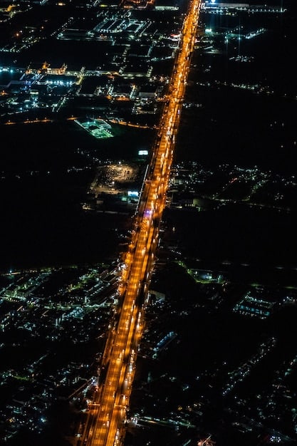 A satellite image showing economic activity lights dimming over a major city in a sanctioned country, contrasted with bustling nearby countries, visually representing the impact of economic sanctions on a nation's infrastructure and daily life.