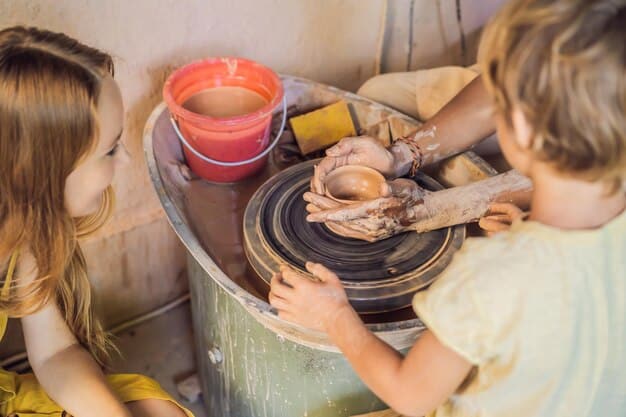 A group of excited children participating in an outdoor pottery workshop, with colorful clay and smiles, demonstrating hands-on learning in the arts.