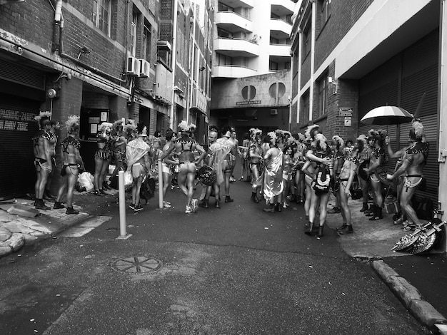A vibrant street scene from the 1960s, showing a crowded sidewalk with people of diverse backgrounds. A protest sign for Civil Rights is visible in the background, subtly connecting the era's social movements with the music discussed.