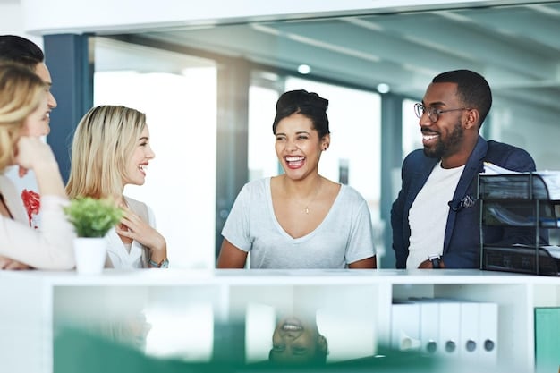 A diverse group of colleagues in an office setting, smiling and engaging in a casual conversation, depicting a positive and supportive work environment.