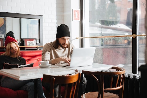 A student sitting comfortably at a coffee shop, engrossed in a laptop with educational content displayed. The background shows blurred city life, emphasizing flexibility and mobility in online learning.