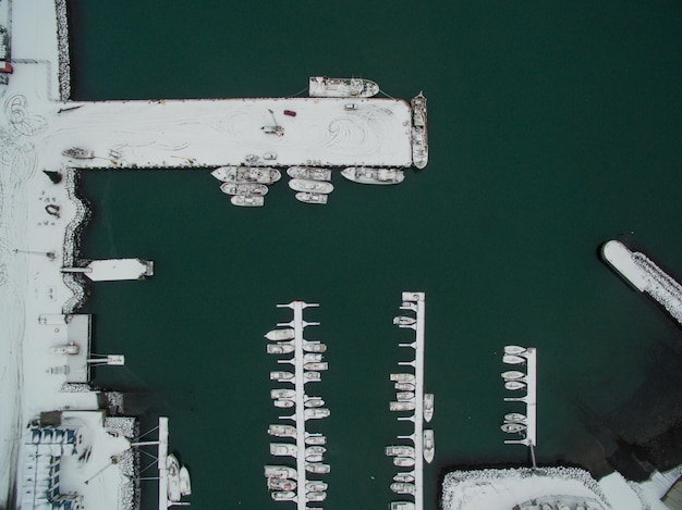 An aerial view of a modern naval fleet, including an aircraft carrier and several destroyers, sailing in formation across open waters, symbolizing naval power and strategic projection.