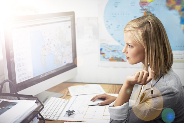 A researcher meticulously analyzing data on a computer screen, with global maps and policy documents spread on a desk, illustrating the rigorous analytical work within a think tank.