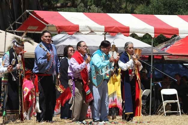 A diverse group of event staff, some wearing vests and others preparing food, bustling around a festival tent, illustrating the various job roles created by cultural events.