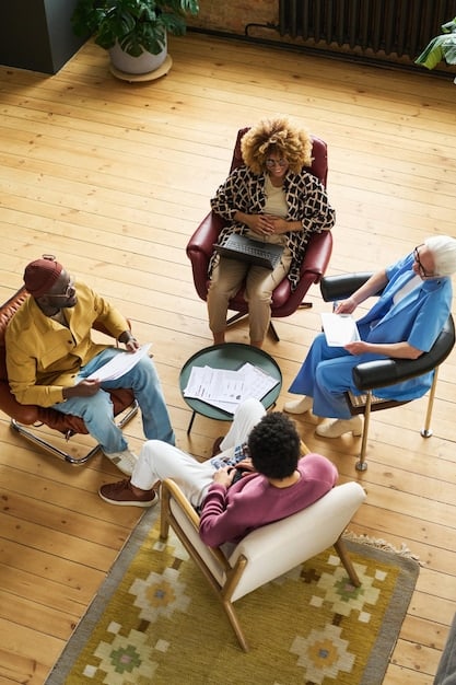 A diverse group of people sitting in a circle in a supportive group therapy setting. They are engaged in discussion, showing empathy and connection. The lighting is warm and inviting.