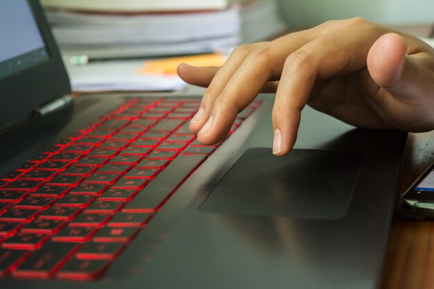A detailed, close-up shot of hands typing on a laptop keyboard, with a scholarship application form visible on the screen, emphasizing the digital aspect of the application process.