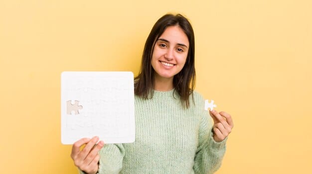 A person holding two puzzle pieces, one labeled 